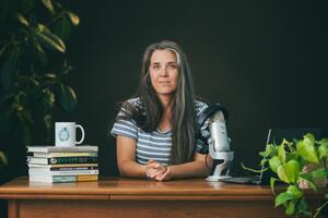 Claudia sits with a microphone and books